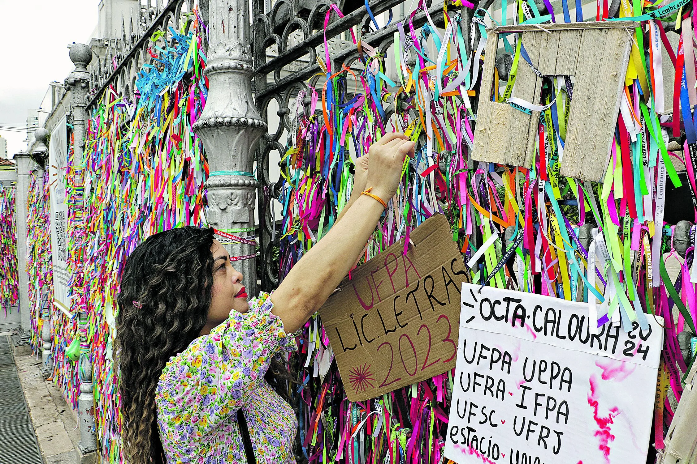 Paula Miranda amarra uma fitinha na grade da Basílica e faz um pedido pela filha que está se preparando para o vestibular