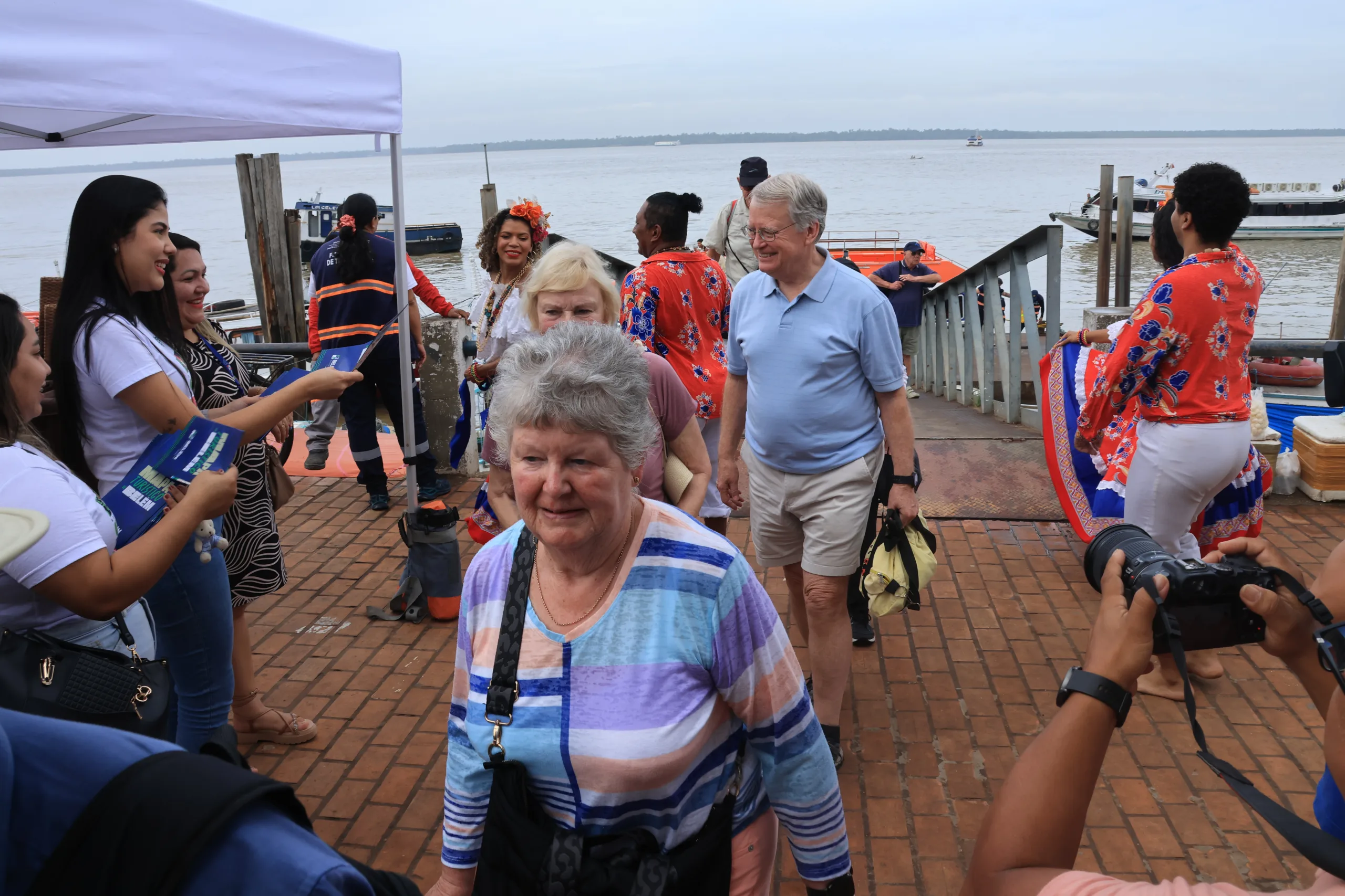 Recepção calorosa em Belém: turistas internacionais são acolhidos com música local e hospitalidade durante cruzeiro pela Amazônia.