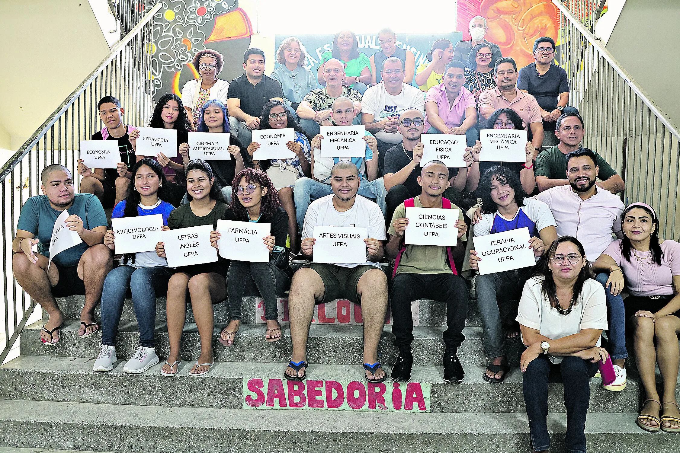 Segurando as placas com os nomes dos cursos, os alunos mostram a alegria da conquista das vagas no ensino superior