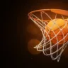 3d rendering of a basketball in the net on a dark background. Win game. Be success. Teamwork is key to triumph.