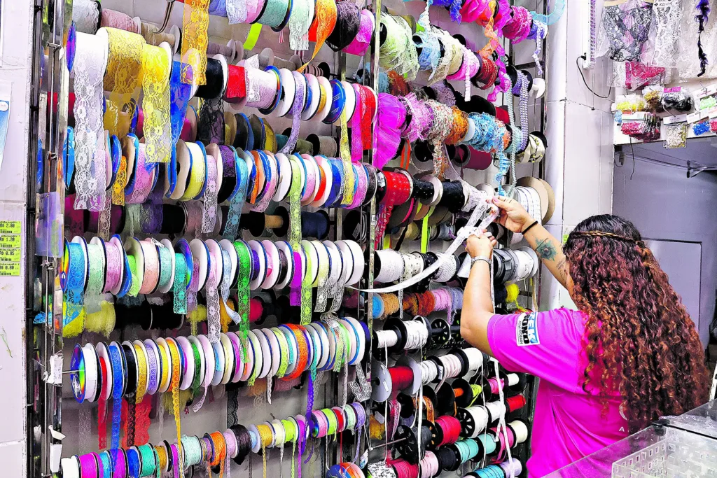Rendas e fitas de cetim estão entre os produtos mais procurados. Abaixo, a vendedora Yasmim Sena

 