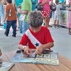 O menino Enzo Haniel preenche seu álbum durante evento na Usina da Paz do Benguí – Foto: Divulgação Vale