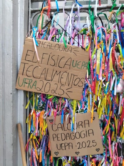 Calouros penduram placas com seus cursos em agradecimento a Nazinha. Fotos: Clayton Matos